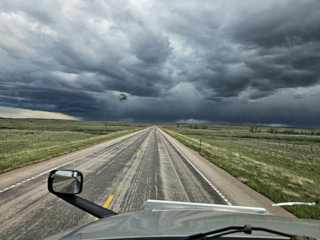 Open prairie highway under storm clouds