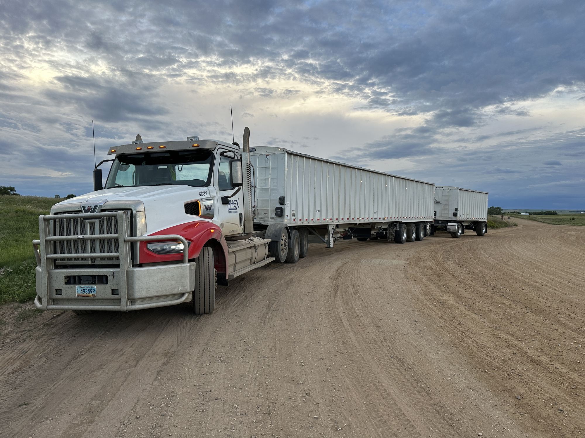 Red and white truck with sand trailers